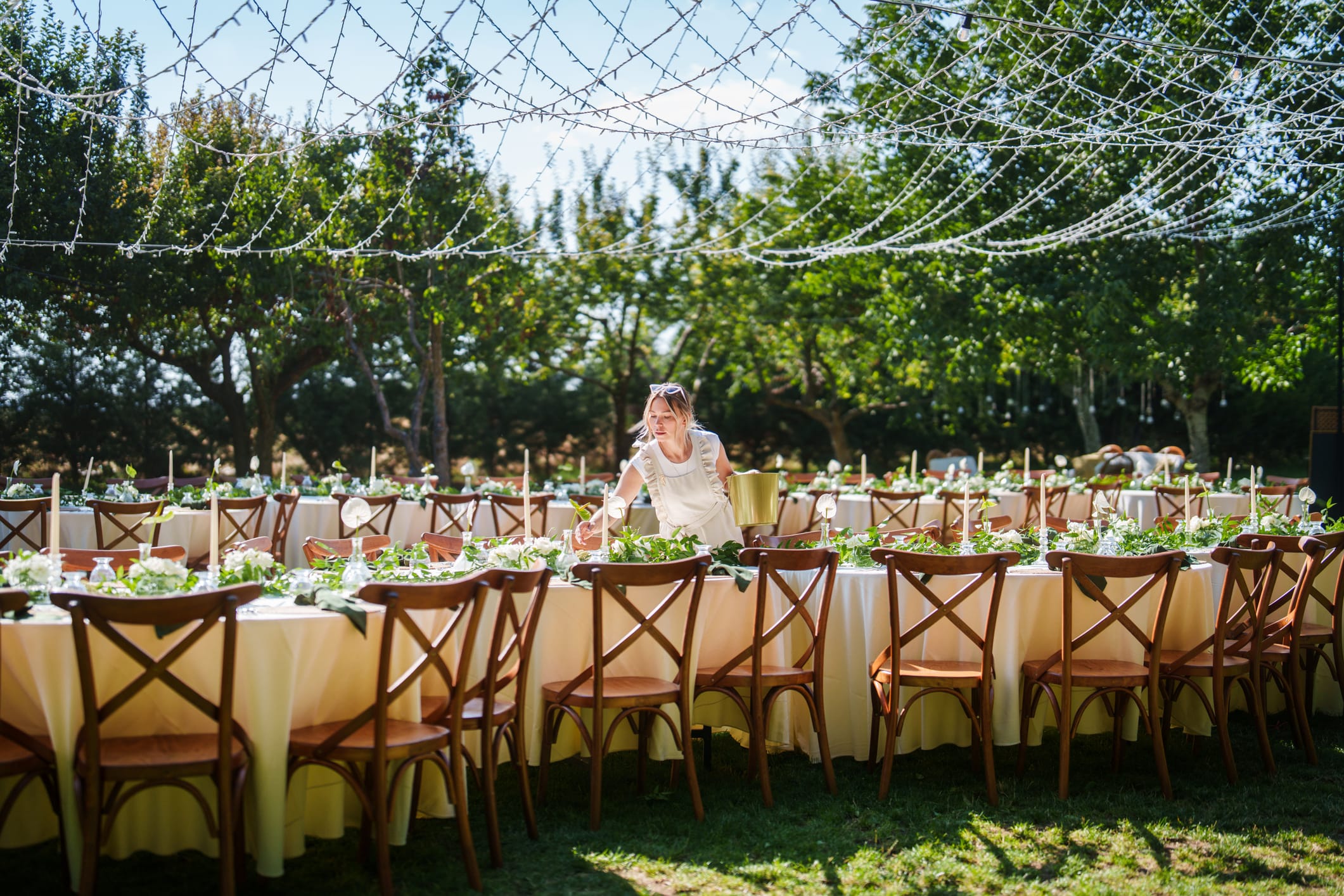 Outdoor event tables, chairs, and linens arranged for a celebration